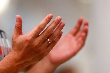 Catholic mass.   The Lord's Prayer also called the Our Father.  Close up on hands.  Thi Nghe Church.  Ho Chi Minh City. Vietnam. 