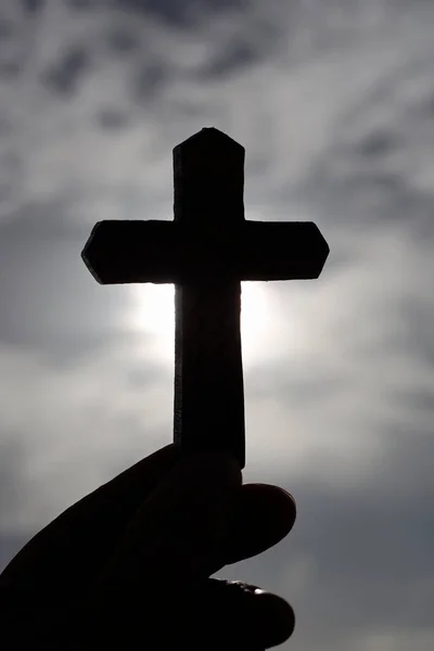 Christian wooden cross against black sky. Close-up.