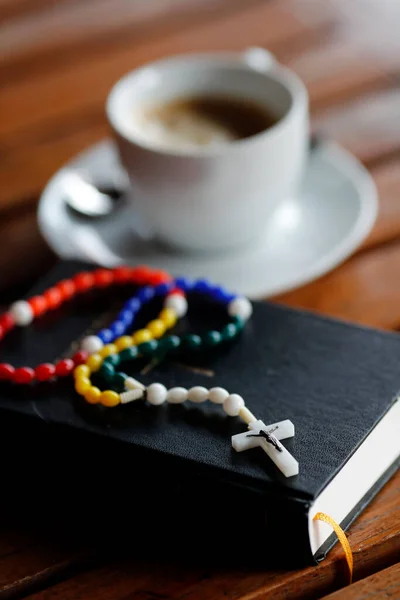Colorful rosary,  holy bible and cup of coffee.