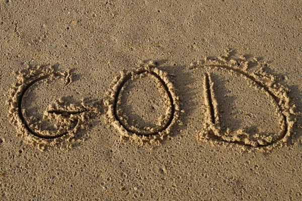 The name of God written in wet sand on beach.
