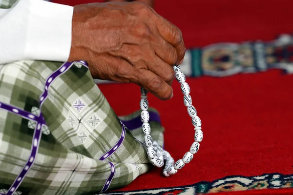 Muslim praying with Tasbih (prayer beads), Close-up.
