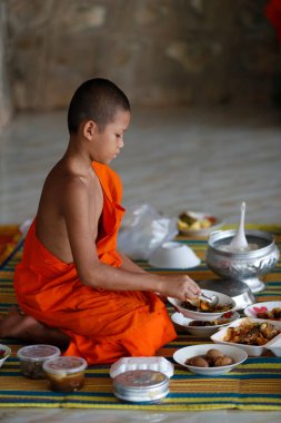 Young mons at lunch in a buddhist temple.  Kep. Cambodia.  clipart