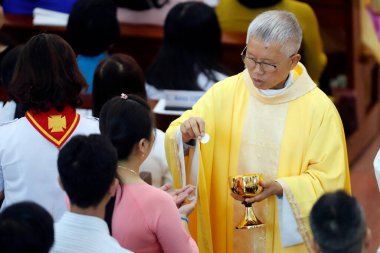 Katolik ayini. Katolik ayini. Rahip kutsal ayin yapıyor. Bien Hoa. Vietnam. 