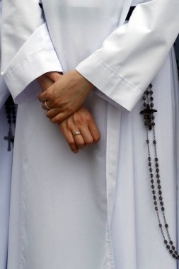 Dominikli kız kardeş. Elleri ve tespihi yakın plan çek. Bien Hoa. Vietnam. 