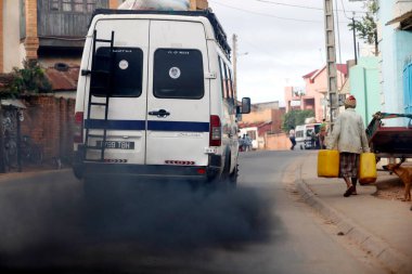 Old minibus emitting black smoke on road. Pollution.  Antananarivo. Madagascar. 