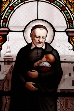 Saint Francis de Sales Kilisesi. Lekeli cam pencere. St. Vincent de Paul kendini fakirlere hizmet etmeye adamış bir Fransız Katolik rahibiydi. Cenevre. İsviçre. 
