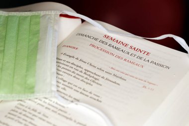 Coronavirüs salgını (COVID-19). Okuyucuda cerrahi maske. Kutsal haftanın kutlaması. Avuç içi. Fransa. 