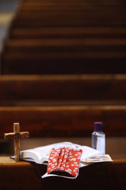 Coronavirüs salgını (COVID-19). İncil, alternatif maske ve kilisede hidroterapi jeli. Sosyal uzaklık. Sallanch 'lar. Fransa. 