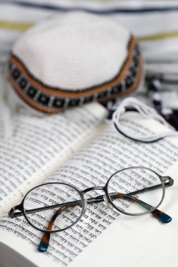 Tevrat 'ı aç, kippah, Tallit ve bir çift gözlük. Dini sembol. 