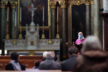 Coronavirus salgını sırasında kilise. COVID-19 talimatları: Katolik kutlaması sırasında jel dezenfekte etme, cerrahi maske ve sosyal mesafeler. Annecy. Fransa. 
