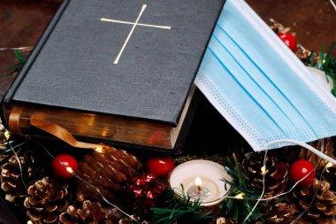 Advent çelengi, İncil ve cerrahi maske. Noel kompozisyonu. 
