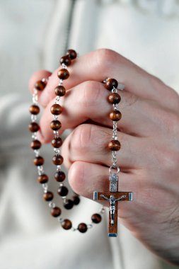 Katolik adam tespih ile dua ediyor. Ellerinizi kapatın. Fransa. 