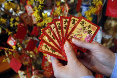 Tu An pagoda. Çin ve Vietnam yılbaşı için sarı ağaçta kırmızı zarflı Budist kadın (hongbao). Kırmızı renk iyi şansın sembolüdür. Aziz Pierre en Faucigny. Fransa. 