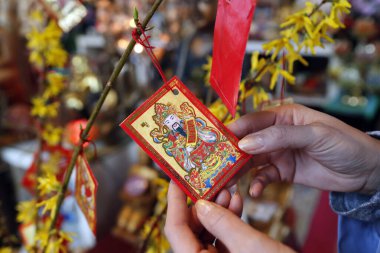 Tu An pagoda. Çin ve Vietnam yılbaşı için sarı ağaçta kırmızı zarflı Budist kadın (hongbao). Kırmızı renk iyi şansın sembolüdür. Aziz Pierre en Faucigny. Fransa. 