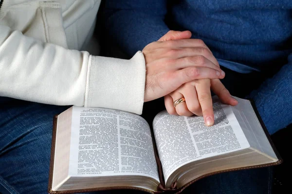 Man and woman reading together the bible at home. Christian couple living in the love of God and Jesus.