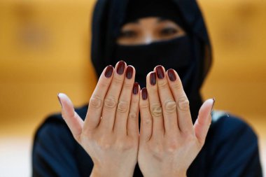 Abaya 'daki Müslüman kadın elleri havada dua ediyor. Din duası kavramı. Birleşik Arap Emirlikleri