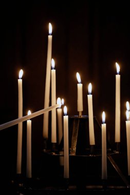 Katolik bir kadın kilisede mumlarla dua ediyor. Kilise kilisede iptaller. Meryem Ana 'ya dua eden kadın. 