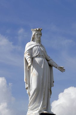 Mavi gökyüzüne karşı Bakire Meryem 'in beyaz heykeli. Fransa. 