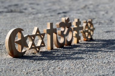 Kum üzerinde dini semboller. Hıristiyanlık, İslam, Yahudilik, Ortodoksluk Budizm ve Hinduizm. Dinlerarası ya da dinler arası kavram