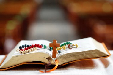 Rosary and open bible on altar. Catholic church.  France.  clipart