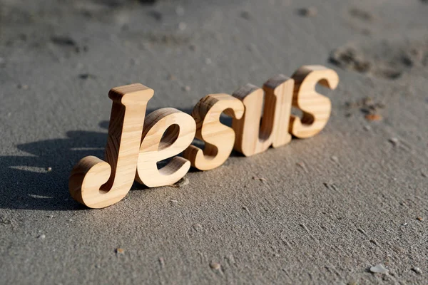 Ξύλινα Γράμματα Που Σχηματίζουν Λέξη Ιησούς Φόντο Άμμου Παραλίας Χριστιανικό — Φωτογραφία Αρχείου