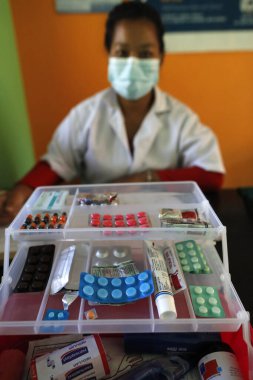 İlkokulda bir revirde. Çocuklar için ilaçları olan bir hemşire. Nepal. 