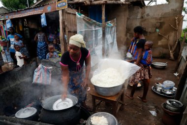 Sokak restoranında pilav pişiren Afrikalı bir kadın. Benin.. 
