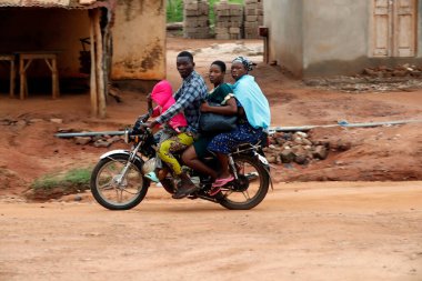 Yolda motosiklet süren Afrikalı bir aile. Benin.. 