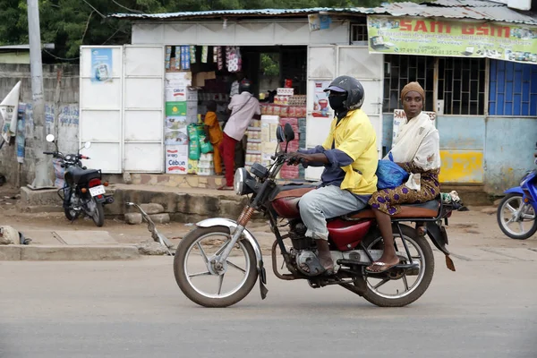 Motosiklet süren Afrikalı insanların olduğu sokak sahnesi. Benin.. 