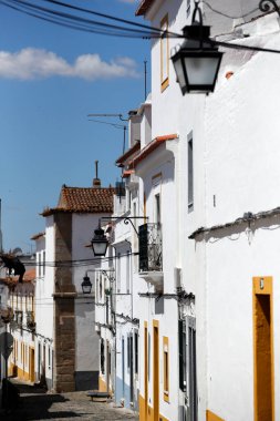 Taş sokak, tipik beyaz ve sarı evlerin yanında. Evora. Portekiz. 