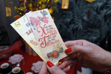 Vietnamlı yeni yıl kutlaması için zarfları olan Asyalı bir kadın. Evde din var.. 