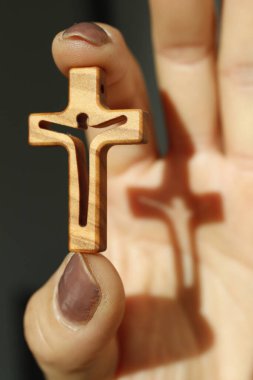 Başparmağıyla işaret parmağı arasına haç takmış Hristiyan bir kadın. İnanç ve din. 