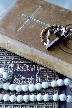 Dini semboller: Müslüman Dua Boncukları ve Kuran, Hristiyan Tespihi ve İncil. Dinler arası veya dinler arası diyalog kavramı. 
