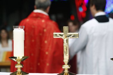 Katolik kilisesinde ayin yapan bir rahip. Kilise iptali ve mihrapta haç. İsviçre.