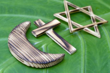 Hristiyanlık, İslam, Musevilik 3 tek tanrılı din. Yeşil yapraklı Yahudi Yıldızı, Yıldız ve Hilal ve Katolik Haçı. Dinlerarası, dinler arası ve ekoloji sembolleri.