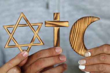 Üç elde dini semboller. Yahudi Davut Yıldızı, Müslüman yıldız ve Hilal, Hıristiyan Haçı. Din, dinler arası ve dinler arası diyalog kavramı. 