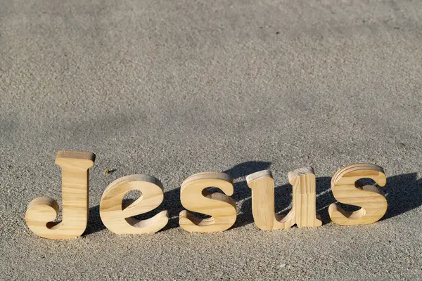 Dřevěné Písmena Tvořící Slovo Ježíš Biblí Pozadí Plážového Písku Symbol — Stock fotografie