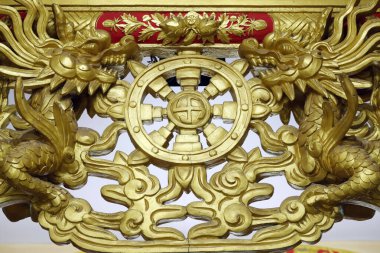 Uzun Duc Budist tapınağı. İki ejderha ve Dharma Çarkı. Dharmachakra, sekiz katlı Budist yolu bir tekerlekte resmedildi. Tan Chau. Vietnam. 