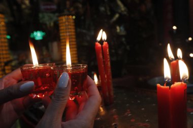 İmparator Jade Pagoda (Chua Ngoc Hoang veya Phuoc Hai Tu). Taoist tapınağı. Elinde kırmızı mumlarla dua eden bir kadın. Adaklar. Ho Chi Monh şehri. Vietnam. 