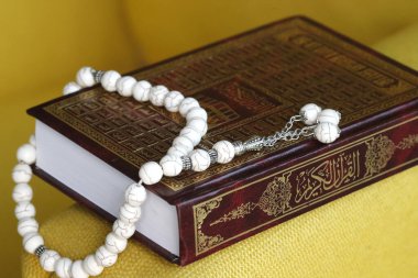 Arapça Kur 'an' ın önünde ve müslüman dua boncuklarıyla. İslam sembolleri. Dubai 'de. Birleşik Arap Emirlikleri.