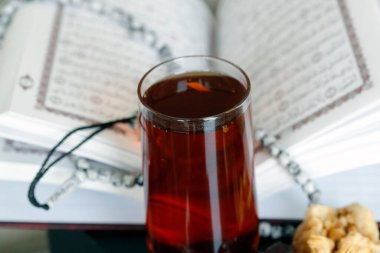 Arapça kutsal Kur 'an, müslüman tespihi, bir bardak çay. İslam sembolleri ve Ramazan Kareem kavramı. 