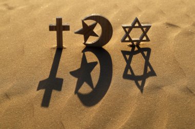 Gün batımında kumdaki dini semboller: Yahudi Davut Yıldızı, Müslüman Yıldızı ve Hilal ve Catholc Haçı. Dinlerarası, dinler arası ve ruhsallık kavramı