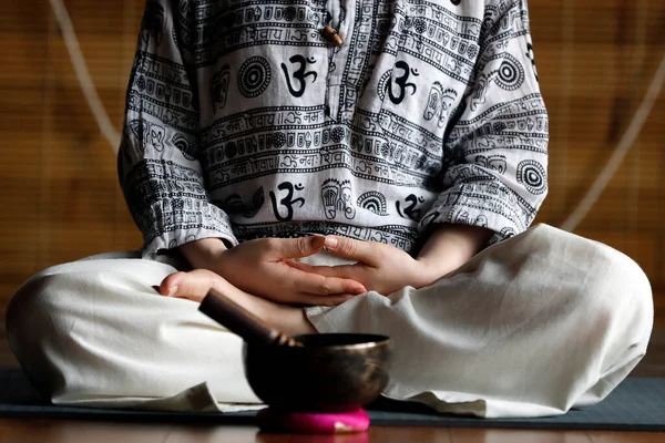 Tibetan bowl is used in sound therapy, meditation and yoga. Buddhist woman practicing a singing bowl for sound therapy in atmosphere for healing, meditation and relax. Vietnam.