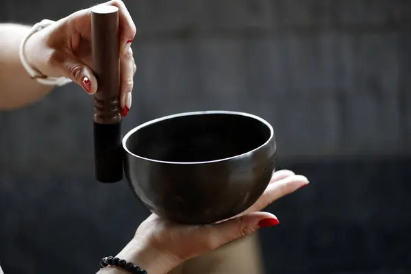 Tibetan singing bowl, buddhist instrument used in sound therapy, meditation and yoga.  Bowl in the hands of prayer.  Vietnam.
