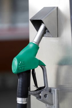 Benzin ve petrol ürünleri kavramı. Yakıt istasyonunda yeşil yakıt tabancası. 