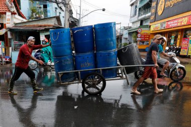 Plastik kutuları yolda taşıyan adamlar. Tan Chau. Vietnam. 