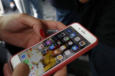 İnternet, oyun, Instagram ve Facebook için iPhone kullanan bir kadın. Vietnam. 