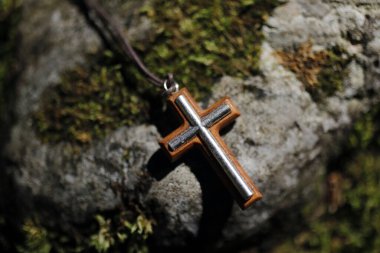 Hıristiyan haçı yosunlu eski bir taşın üzerinde. Fransa. 