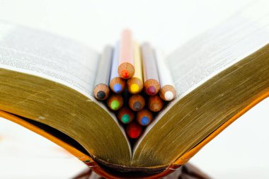 İncil 'in üzerine renkli kalemler. İlmihal. Hıristiyan kökü.