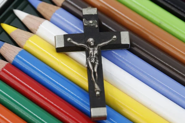 Christian cross and colored pencils. Catechism. Christian curch.